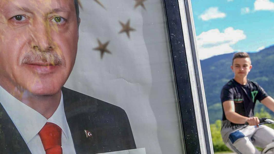 Photo: Cyclist glances at Portrait of Erdoğan.